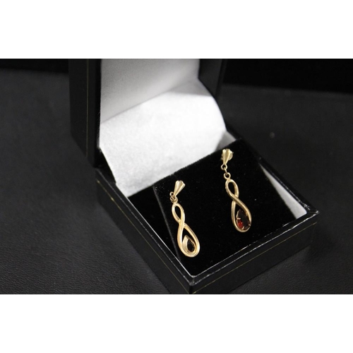 292 - A PAIR OF UNMARKED YELLOW METAL DROPPER EARRINGS SET WITH GARNET TYPE TEARDROP STONES