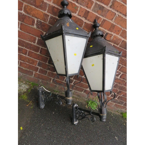 601 - A PAIR OF LARGE EXTERNAL LANTERNS WITH COPPER TOPS, HAVING ORNATE CAST WALL BRACKETS