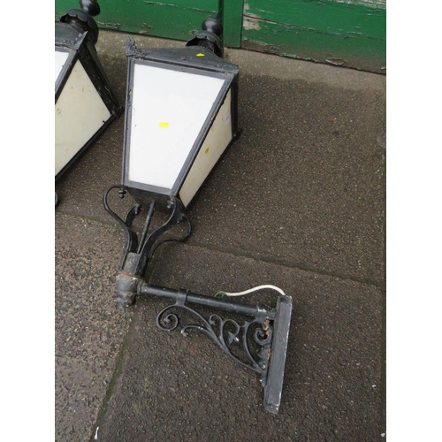 601 - A PAIR OF LARGE EXTERNAL LANTERNS WITH COPPER TOPS, HAVING ORNATE CAST WALL BRACKETS