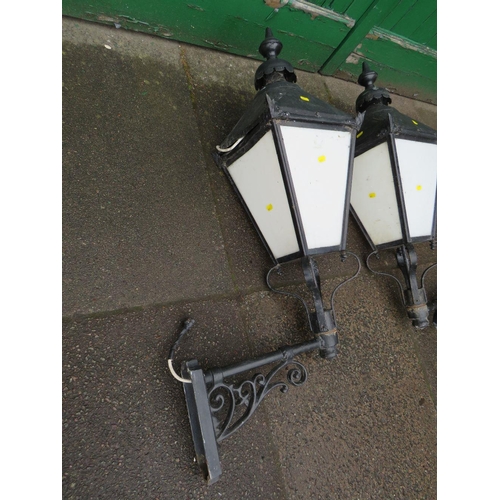 601 - A PAIR OF LARGE EXTERNAL LANTERNS WITH COPPER TOPS, HAVING ORNATE CAST WALL BRACKETS