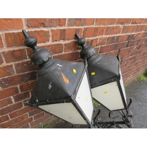 601 - A PAIR OF LARGE EXTERNAL LANTERNS WITH COPPER TOPS, HAVING ORNATE CAST WALL BRACKETS