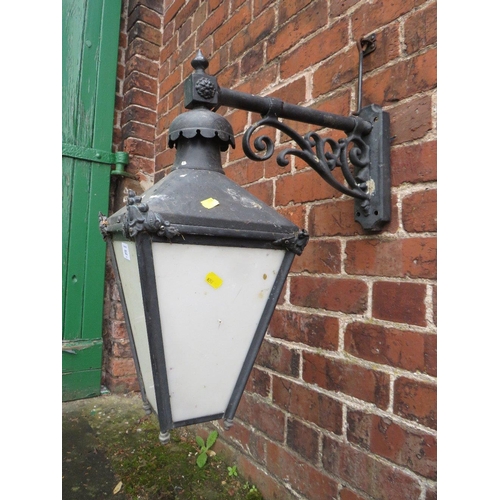 602 - A SMALL EXTERNAL LANTERN WITH COPPER TOP, HAVING ORNATE CAST WALL MOUNTING BRACKET