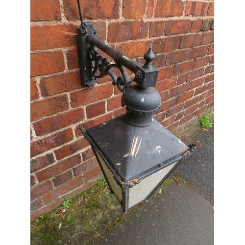 602 - A SMALL EXTERNAL LANTERN WITH COPPER TOP, HAVING ORNATE CAST WALL MOUNTING BRACKET