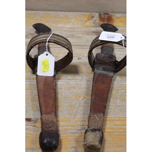 348 - A PAIR OF EASTERN DAGGERS IN LEATHER SHEATHS WITH ARMBANDS