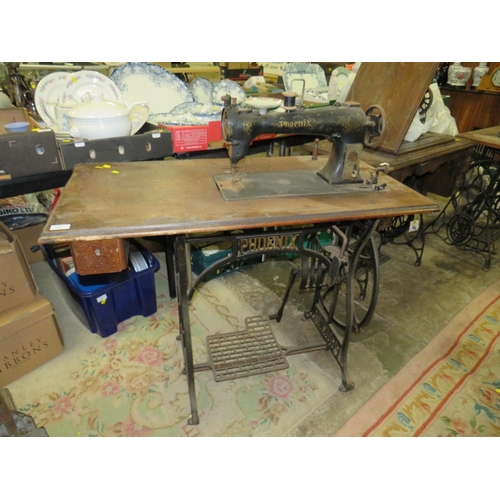 817 - AN ANTIQUE PHOENIX SEWING MACHINE AND TREADLE TABLE