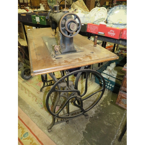 817 - AN ANTIQUE PHOENIX SEWING MACHINE AND TREADLE TABLE