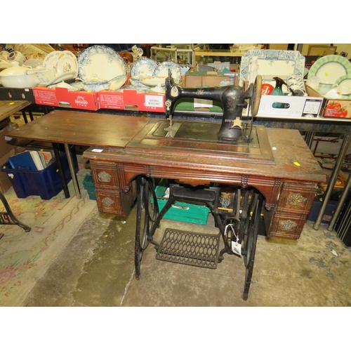 818 - AN ANTIQUE FEDERATION SEWING MACHINE AND TREADLE TABLE