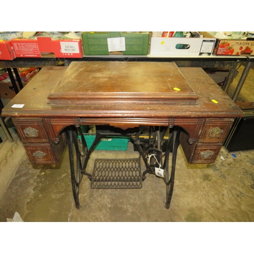 818 - AN ANTIQUE FEDERATION SEWING MACHINE AND TREADLE TABLE