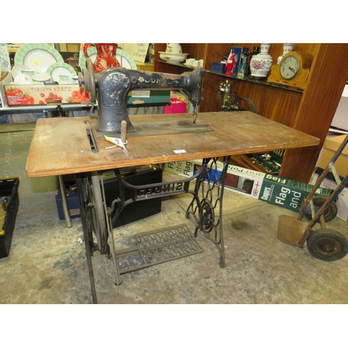 819 - AN ANTIQUE JONES SEWING MACHINE AND TREADLE TABLE