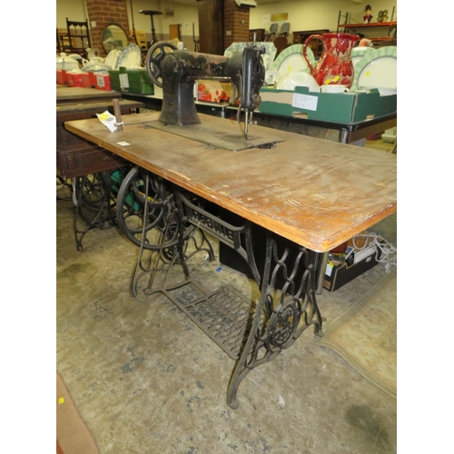 819 - AN ANTIQUE JONES SEWING MACHINE AND TREADLE TABLE