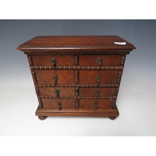 511 - A VICTORIAN MINIATURE OAK COLLECTORS CHEST OF EIGHT DRAWERS, with beadwork detail, raised on bun fee... 