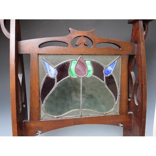 608 - AN EARLY 20TH CENTURY OAK GLAZED ART NOUVEAU FIRE SCREEN, the glass panel with coloured and leaded s... 