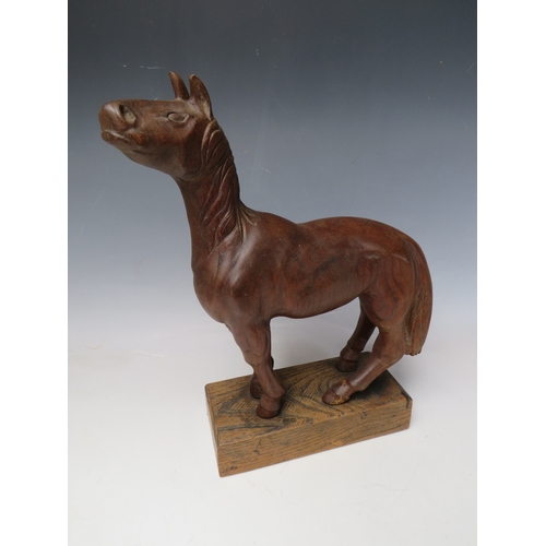 510 - AN EARLY 20TH CENTURY NAIVE WOODEN CARVING OF A HORSE, on a rectangular wooden plinth, Overall H 33 ... 