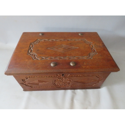 522 - AN ANTIQUE CARVED ZANZIBAR DOWRY CHEST, with twin handles, the hinged lid opening to a fitted interi... 