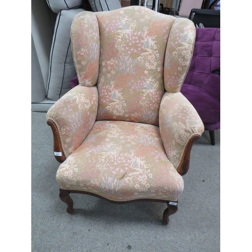 672 - AN UPHOLSTERED ARMCHAIR