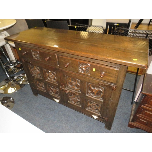 694 - A VINTAGE CARVED OAK SIDEBOARD