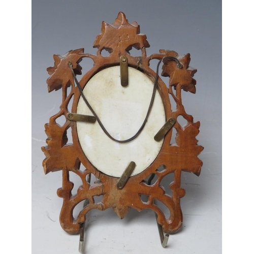 108 - A 19TH CENTURY CONTINENTAL OVAL PORCELAIN PLAQUE OF A LADY READING, unsigned in a carved wooden fram... 