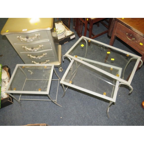 919 - A SMALL SILVER FOUR DRAWER CHEST PLUS A NEST OF GLASS / METAL TABLES (2)