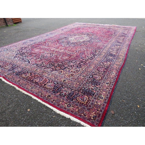 803 - A LARGE EASTERN RED WOOLLEN RUG 508 x 310 cm