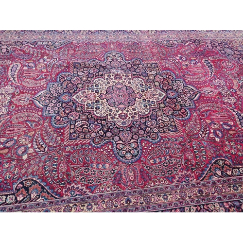 803 - A LARGE EASTERN RED WOOLLEN RUG 508 x 310 cm