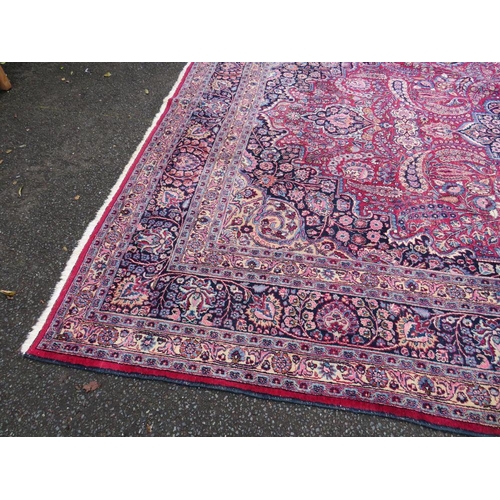 803 - A LARGE EASTERN RED WOOLLEN RUG 508 x 310 cm