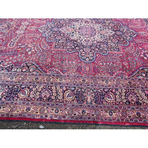 803 - A LARGE EASTERN RED WOOLLEN RUG 508 x 310 cm