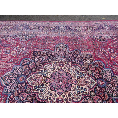 803 - A LARGE EASTERN RED WOOLLEN RUG 508 x 310 cm