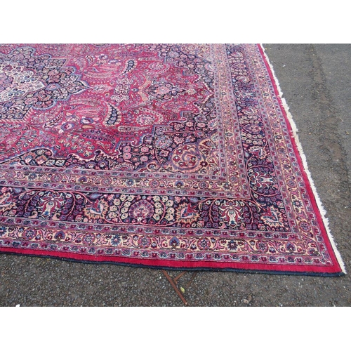 803 - A LARGE EASTERN RED WOOLLEN RUG 508 x 310 cm