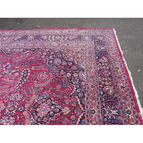 803 - A LARGE EASTERN RED WOOLLEN RUG 508 x 310 cm