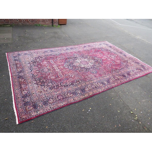 803 - A LARGE EASTERN RED WOOLLEN RUG 508 x 310 cm