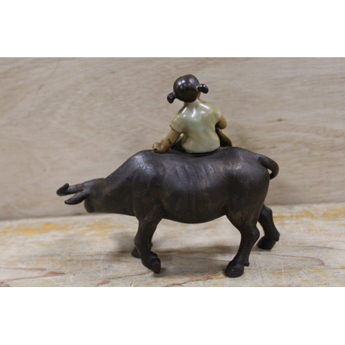 407 - AN ORIENTAL CERAMIC FIGURE OF A YOUNG GIRL SEATED ON A WATER BUFFALO