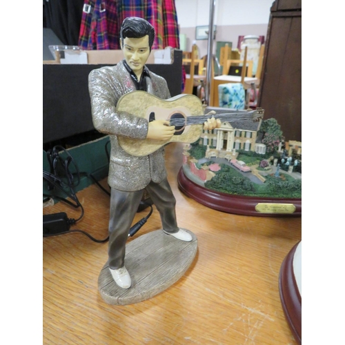 141 - A SELECTION OF ELVIS COLLECTABLES TO INCLUDE TWO GRACELAND MODELS - (ONE LIGHTS UP) AND A AN ELVIS T... 