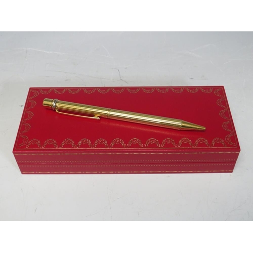 242 - A BOXED CARTIER 'TRINITY' STYLE GOLD PLATED BALLPOINT PEN, together with two refills (unchecked)