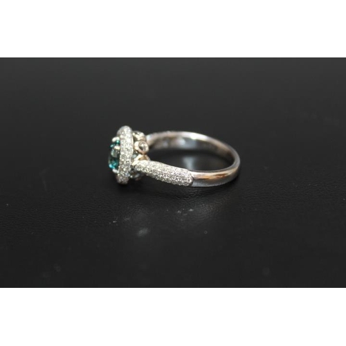 292 - A HALLMARKED 18 CARAT WHITE GOLD BLUE DIAMOND CLUSTER RING, the central brilliant cut blue diamond b... 