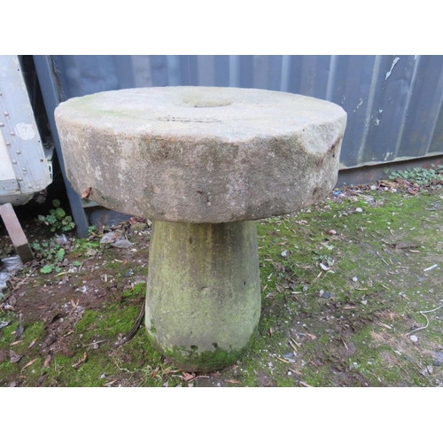 955 - AN ANTIQUE SANDSTONE MILL STONE ON STAND, H 73 cm