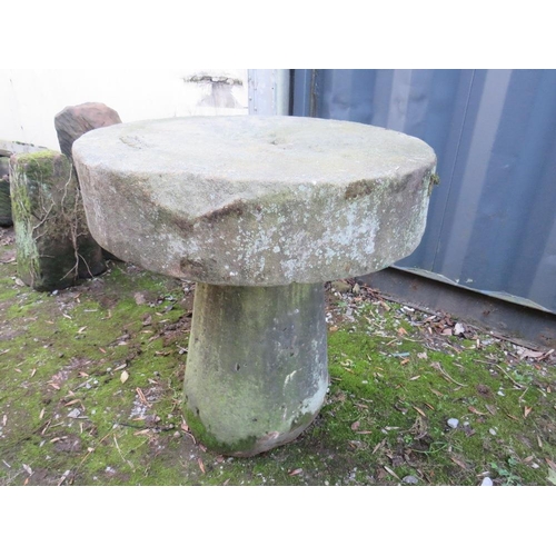 955 - AN ANTIQUE SANDSTONE MILL STONE ON STAND, H 73 cm