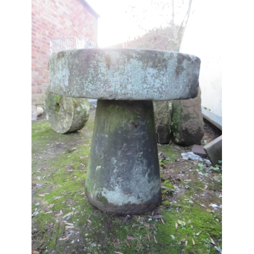 955 - AN ANTIQUE SANDSTONE MILL STONE ON STAND, H 73 cm