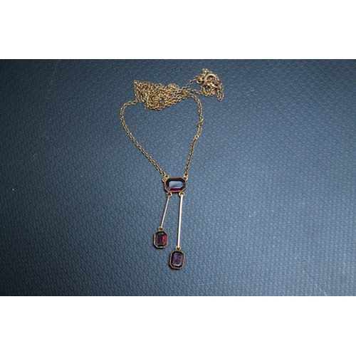 438 - A STYLISH 9CT GOLD DROPPER NECKLACE, set with three emerald cut style garnets - two independently su... 