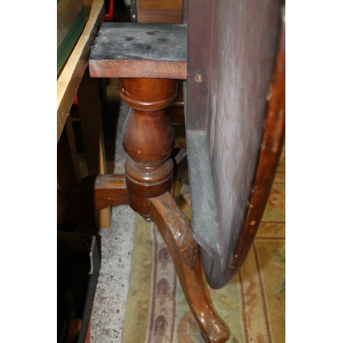 869 - A MAHOGANY TILT TOP OVAL TABLE ON CARVED BASE