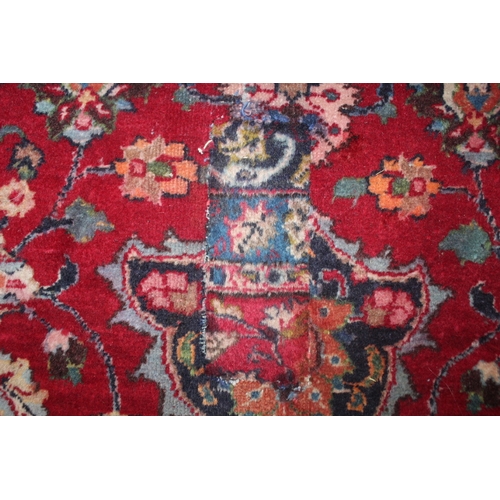 849 - A LARGE EASTERN WOOLLEN RUG IN MAINLY RED AND BLACK PATTERN 377 X 275 CM