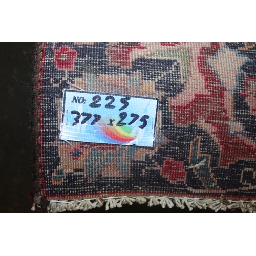 849 - A LARGE EASTERN WOOLLEN RUG IN MAINLY RED AND BLACK PATTERN 377 X 275 CM