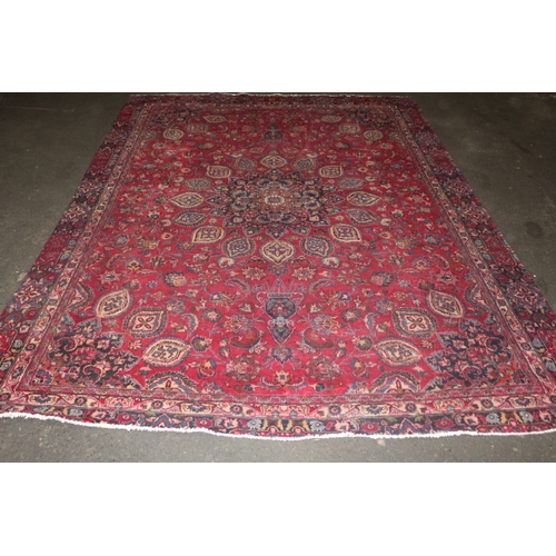 850 - A LARGE EASTERN WOOLLEN RUG IN MAINLY RED AND BLACK PATTERN 362 X 269 CM