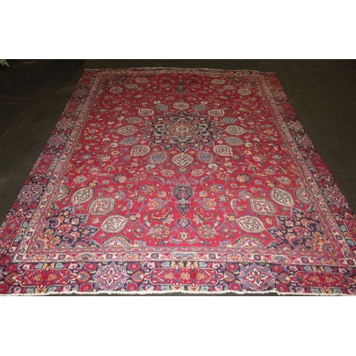 850 - A LARGE EASTERN WOOLLEN RUG IN MAINLY RED AND BLACK PATTERN 362 X 269 CM