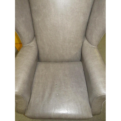 761 - AN UPHOLSTERED WING ARMCHAIR A/F