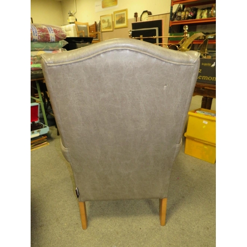 761 - AN UPHOLSTERED WING ARMCHAIR A/F