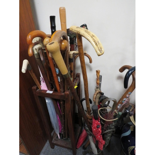 221 - TWO VINTAGE UMBRELLA / STICK STANDS FILLED WITH WALKING STICKS AND UMBRELLAS TO INCLUDE A DISNEY EXA... 