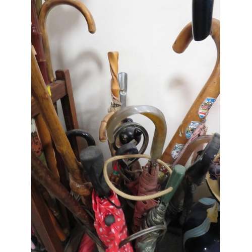 221 - TWO VINTAGE UMBRELLA / STICK STANDS FILLED WITH WALKING STICKS AND UMBRELLAS TO INCLUDE A DISNEY EXA... 