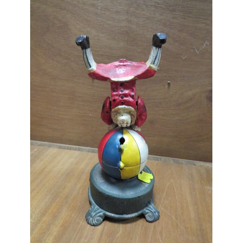 236 - A CAST METAL NOVELTY MONEY BANK IN THE FORM OF A CLOWN ON A BALL