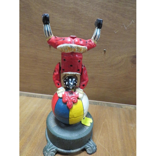 236 - A CAST METAL NOVELTY MONEY BANK IN THE FORM OF A CLOWN ON A BALL