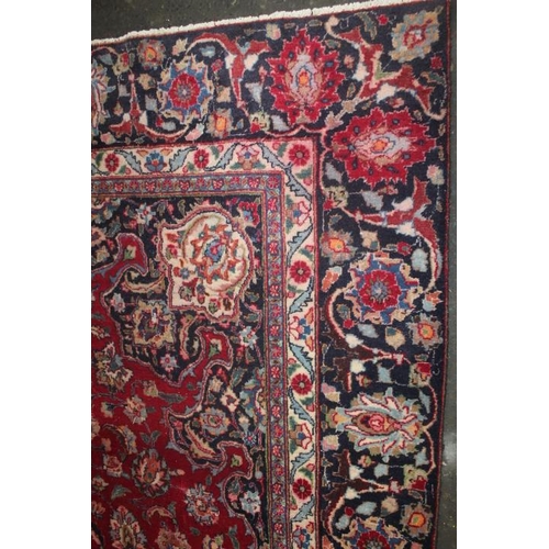 829 - A LARGE EASTERN WOOLLEN RUG IN MAINLY RED AND BLACK PATTERN 377 x 275 cm